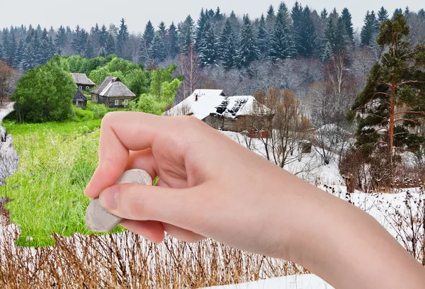 Hand deletes winter village by rubber eraser — Stock Photo, Image
