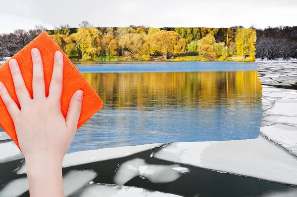 Рука видаляє крижане плаву в річці помаранчевою тканиною — стокове фото