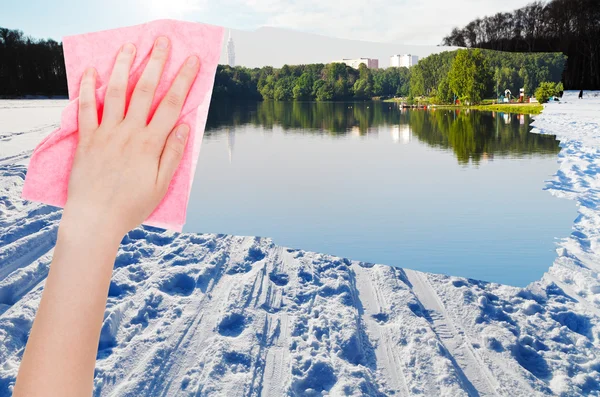 Рука видаляє снігове поле на замерзлій річці тканиною — стокове фото