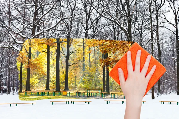 Рука видаляє зимовий міський парк помаранчевою тканиною — стокове фото