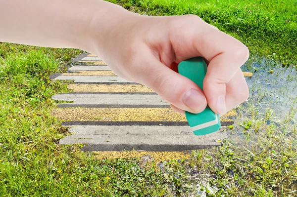 Hand deletes green swamp by rubber eraser — Stockfoto