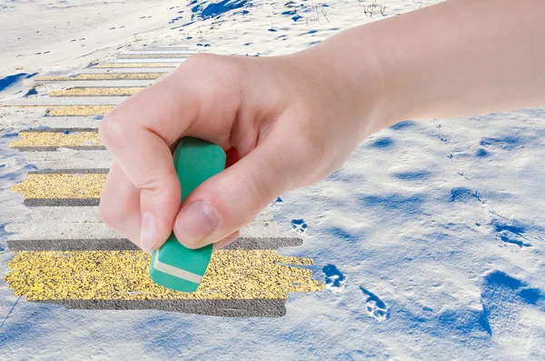 Hand deletes natural snow field by rubber eraser — Stockfoto