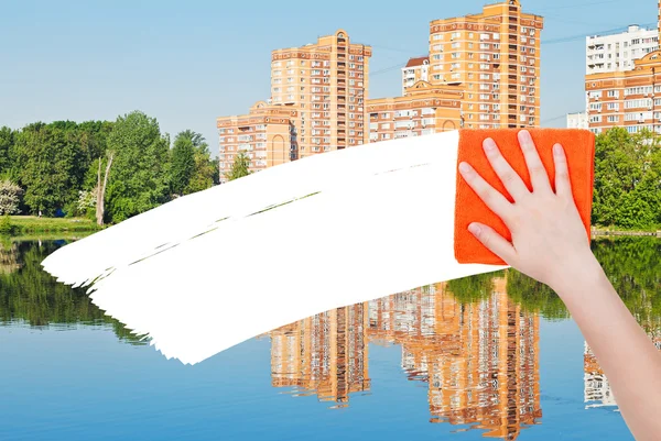 Hand deletes new houses by orange rag — Stock Fotó