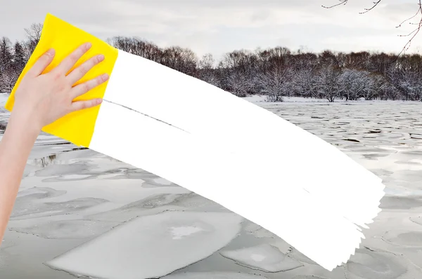 Рука видаляє крижані блоки в річці жовтою ганчіркою — стокове фото