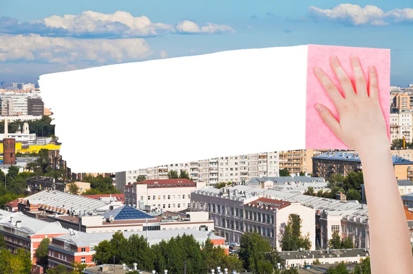 Вручную удаляет городские дома розовой тряпкой — стоковое фото