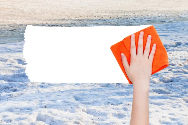 Hand deletes winter snow by orange rag — 图库照片