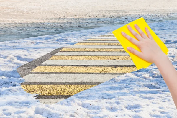 Hand deletes spring snow by yellow cloth — Zdjęcie stockowe