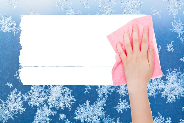 Hand deletes winter frosty pattern by pink rag — Stockfoto