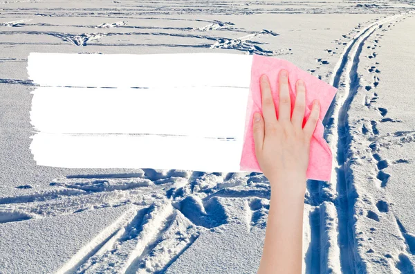 Hand deletes winter snow field by pink rag — Stok fotoğraf