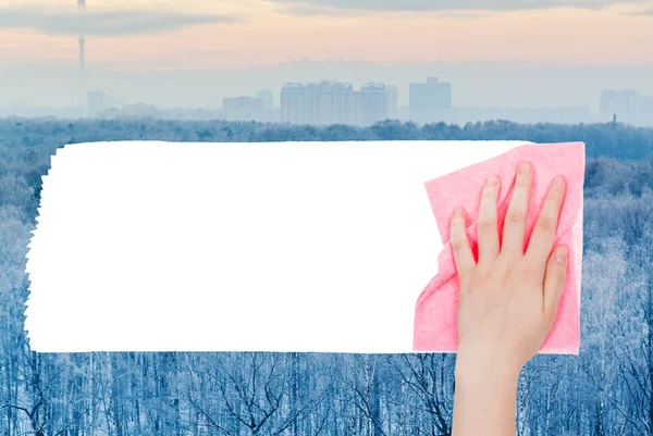 Hand deletes frozen forest by pink rag — Stock Photo, Image