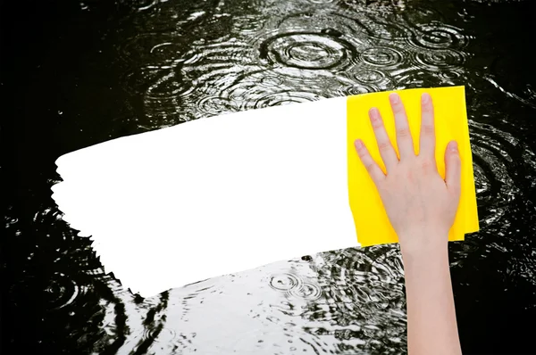 La mano cancella la pozzanghera piovosa da straccio giallo — Foto Stock