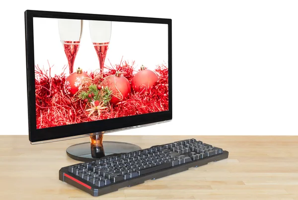 Red baubles and glasses on screen desktop monitor — Stockfoto