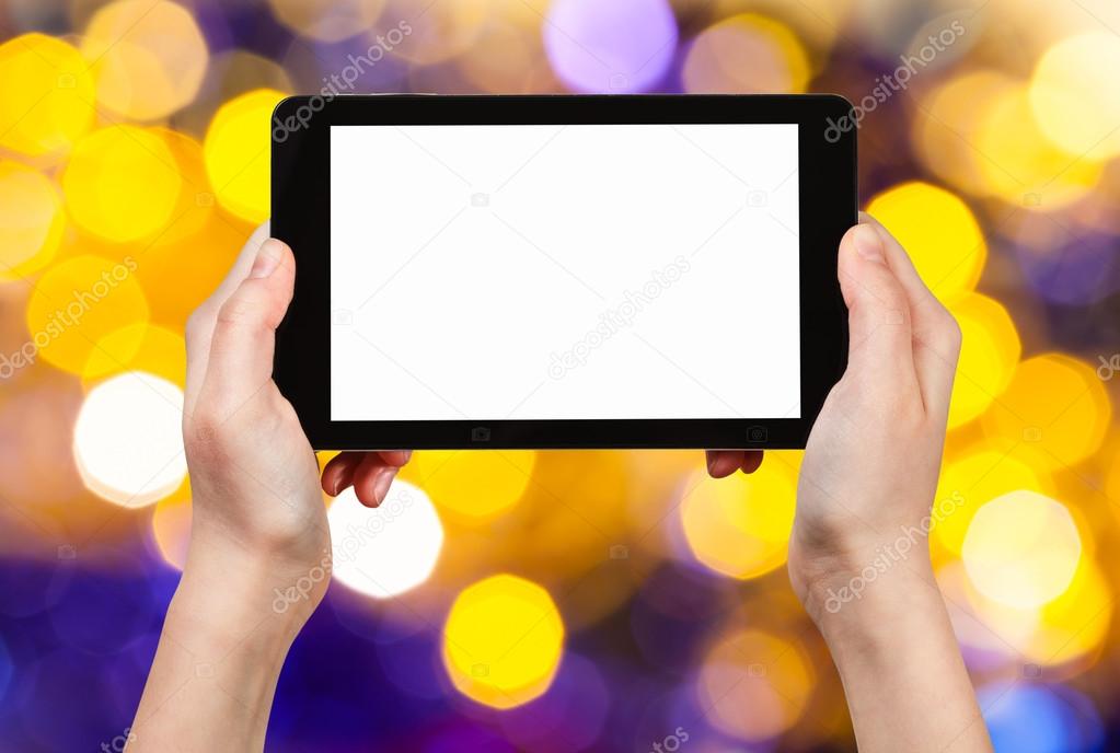 hand with tablet pc on yellow and violet background