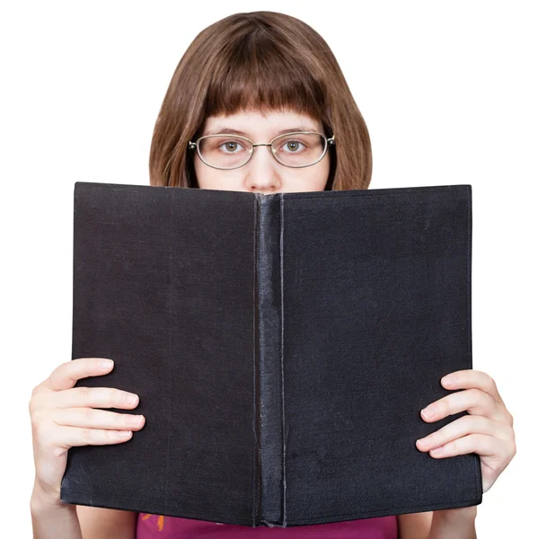 Menina com óculos olha sobre livro grande isolado — Fotografia de Stock