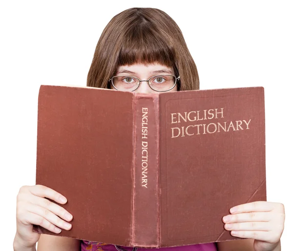 Menina com óculos olha sobre Dicionário Inglês — Fotografia de Stock