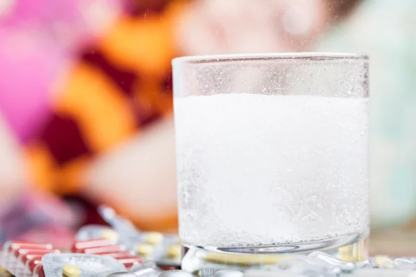 Droge löst sich in Glas und Tablette auf Tisch aus nächster Nähe — Stockfoto