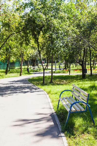 Banco vazio e passarela no jardim público urbano — Fotografia de Stock