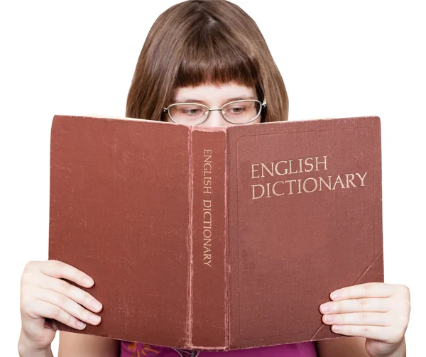 戴眼镜的女孩读英语词典 》 的书 — 图库照片