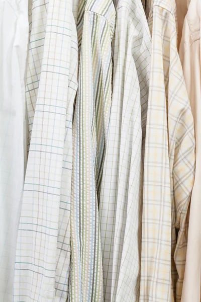 Verschillende mannelijke shirts op hangers in garderobe — Stockfoto