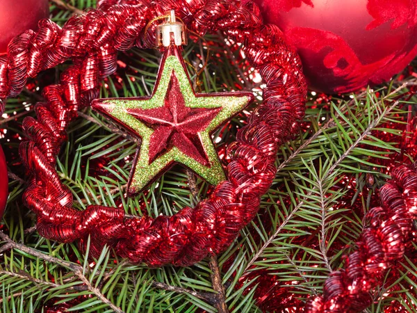 Red star, tinsel on Christmas tree background — Stock Photo, Image