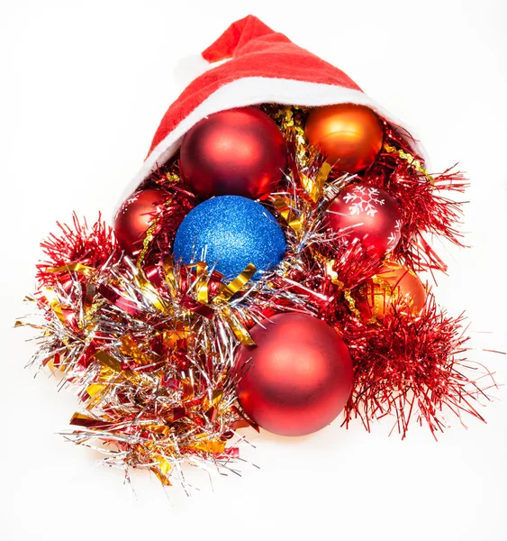 Χριστουγεννιάτικα διακοσμητικά παιχνίδια που χύνονται από κόκκινο καπέλο santa — Φωτογραφία Αρχείου