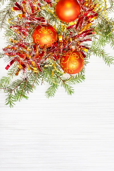 Три оранжевых рождественских безделушки и веточка на чистой бумаге — стоковое фото