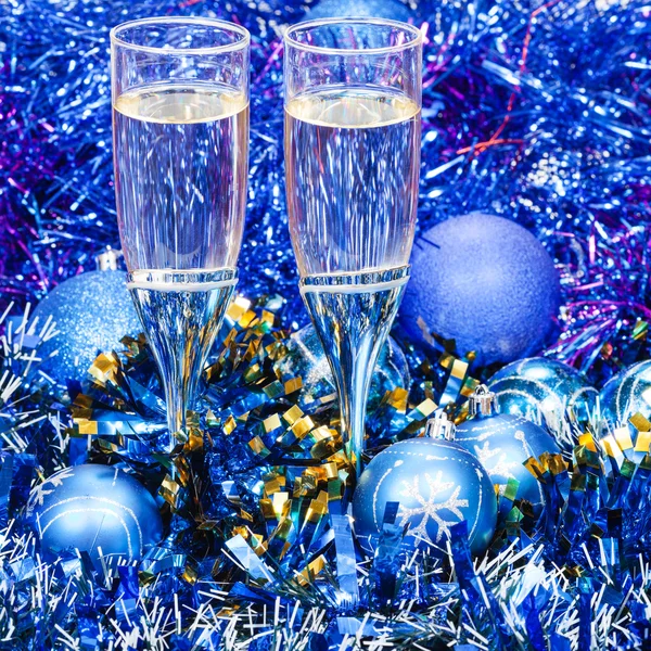 Sparkling wine glasses in blue Xmas decorations — Stock Photo, Image
