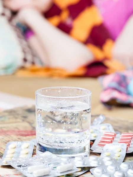 Glas met geneesmiddel en pillen op tafel close-up — Stockfoto