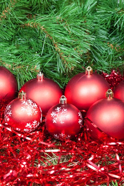 Many red Christmas balls, tinsel and Xmas tree — Stock Photo, Image