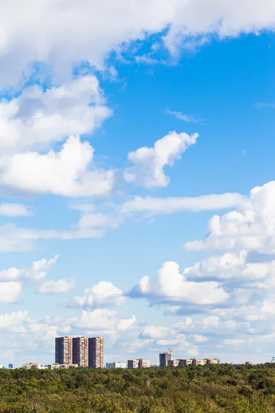 Ciel bleu avec nuages blancs sur les bâtiments urbains — Photo