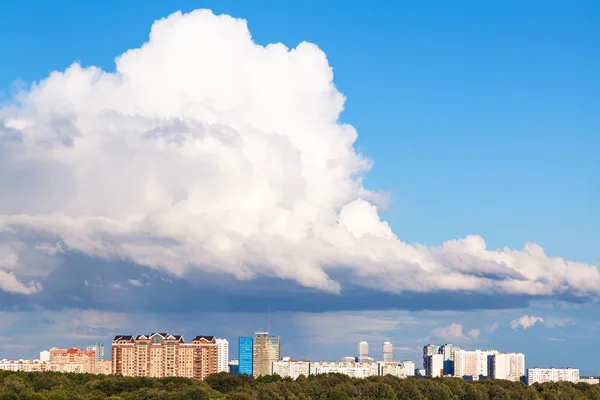 Dużych niskie chmury białe w błękitne niebo nad miasto — Zdjęcie stockowe
