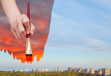 paintbrush paints red sunset over daily city