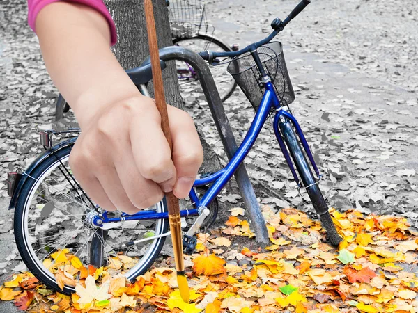 Pennello dipinge foglie gialle sulla strada urbana — Foto Stock