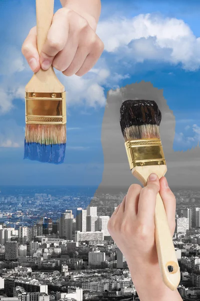 paintbrush paints black and blue side of city