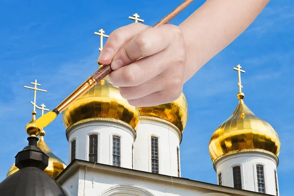 Paintbrush paints golden cupola on russian church — Stockfoto