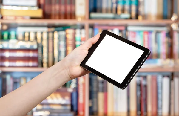 Hand holds tablet pc in library — Stock Photo, Image