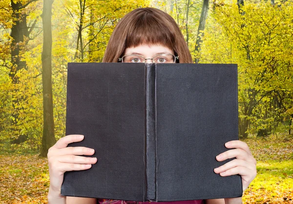 Chica torres sobre gran libro y bosque soleado —  Fotos de Stock