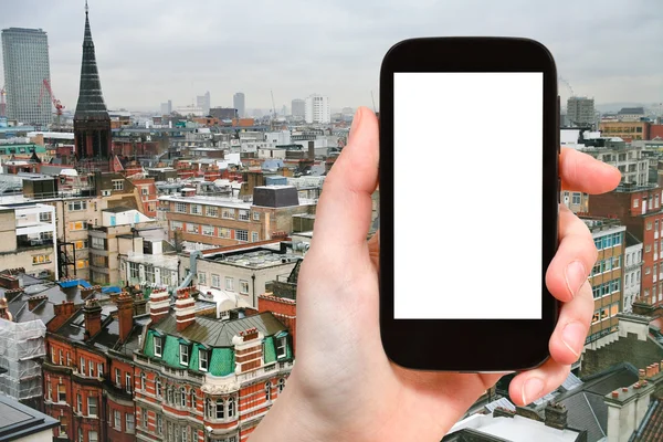 Smartphone with cut out screen and London skyline — Stock fotografie