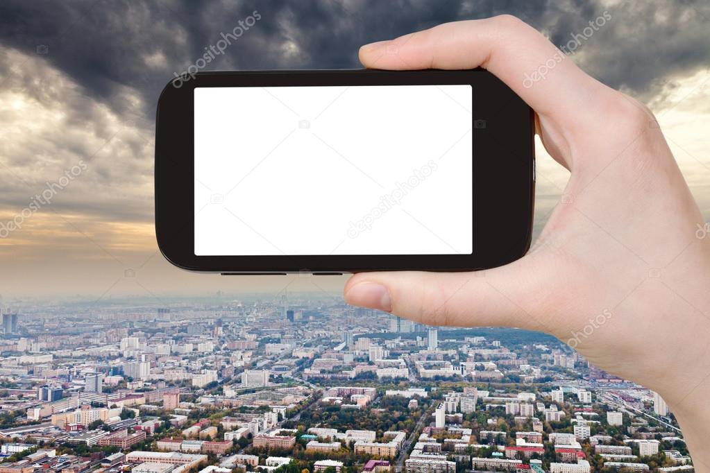 smartphone and storm clouds over city