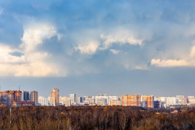 Sonbahar günü yeni yerleşim bölgesi ve şehir parkı üzerinde mavi bulutlu gökyüzü
