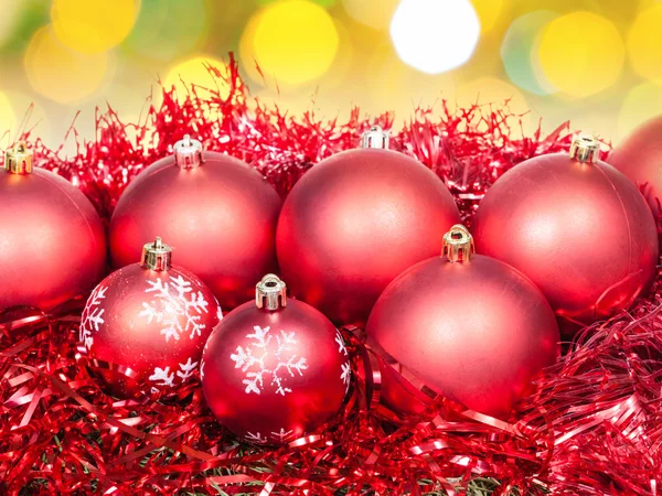 Xmas red balls and tinsel on yellow background Royalty Free Stock Images