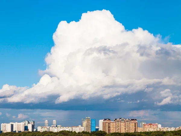 Gran nube baja en el cielo azul sobre la ciudad en verano —  Fotos de Stock