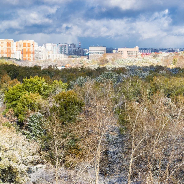 Nubes de tormenta sobre la ciudad y primera nieve en los bosques —  Fotos de Stock