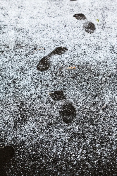 Ludzkie ślady na chodniku objęte pierwszy śnieg — Zdjęcie stockowe