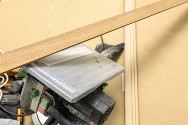 Taşınabilir dairesel testerenin üzerindeki ahşap süpürgelik daireyi yenileme sırasında odadaydı.