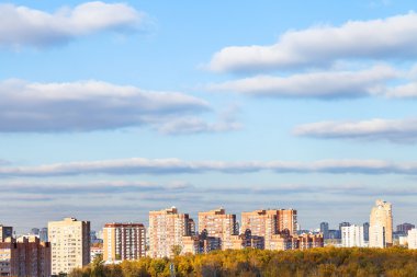 blue sky with clouds over modern houses in autumn