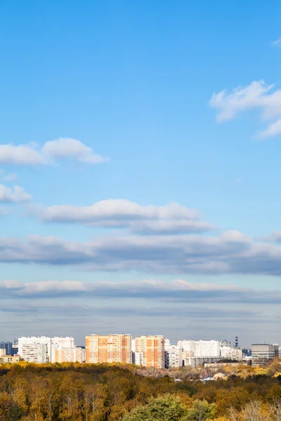 Céu azul com nuvens sobre a cidade e bosques no outono — Fotografia de Stock