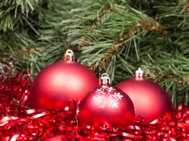üç kırmızı Noel baubles, tinsel ve Xmas ağacı