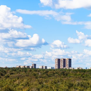 Beyaz bulutların üzerinde kentsel evleri ile mavi gökyüzü