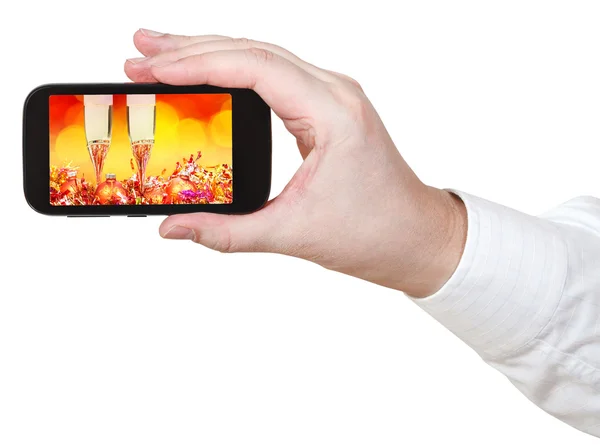 Affärsman innehar smartphone med Xmas stilleben — Stockfoto